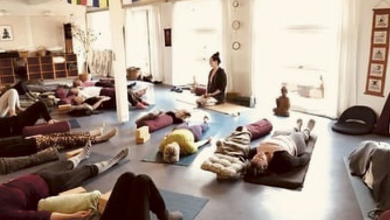 Liggende mennesker i yogastudie