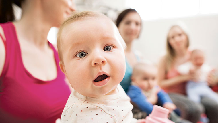 Baby kigger med kvinder i baggrunden