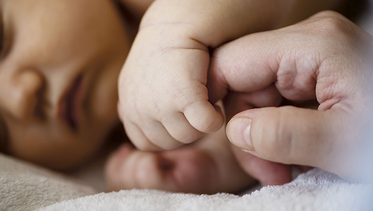 Baby griber om mors finger