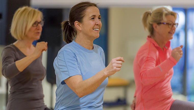 Tre personer træner energisk indendørs