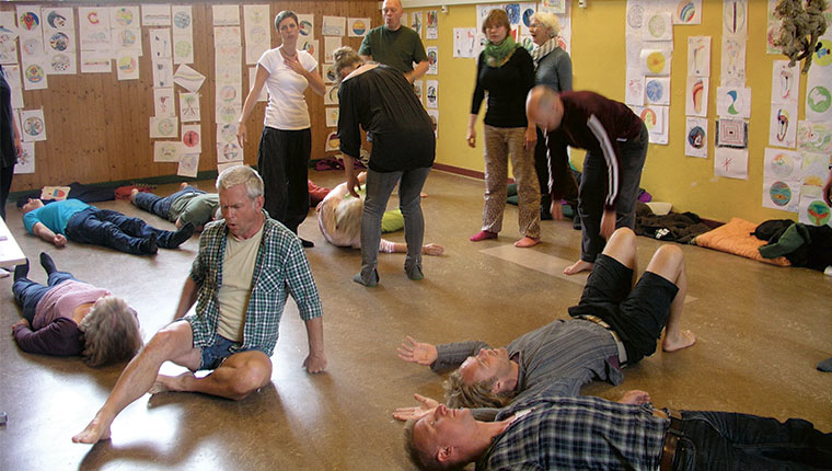 Deltagere og Marianne på gulv med tegninger i baggrunden